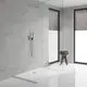 Dusche mit runder Kopfbrause und Handbrause von Grohe, verchromte Oberflächen, in einem modernen Bad mit großen Fensterfronten und einem Holzstuhl mit Handtüchern.