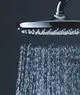 Grohe Kopfbrause mit wasserführenden Düsen, aus verchromtem Material, strömt Wasser in gleichmäßigen Strahlen nach unten, vor dunklem Hintergrund.
