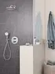 Dusche mit horizontaler Glasabtrennung, Grohe Kopfbrausenarm und Handbrause, Wandmontage, neben einem Waschtisch mit Pflegeprodukten und Handtuch.