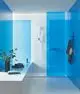 GROHE Handbrause in einem modernen Badezimmer mit blauen Wänden und einem Duschbereich, abgetrennt durch eine transparente Glasscheibe.