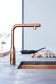 Küchenarmatur in Kupferoptik von Grohe mit einem langen, gebogenen Auslauf und einem integrierten Sprühkopf, platziert neben einem Abtropfabtropfer mit Eiern.