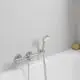 Wannenbatterie von Grohe mit integriertem Handbrause-Halter und Bedienungselementen für Temperatur- und Wasserdurchflussregelung, montiert an heller Wand.