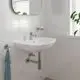GROHE Waschbeckenarmatur in chrom, mit einem minimalistischen Design, installiert über einem modernen, weißen Waschbecken in Badezimmer mit Fliesen und natürlichem Licht.