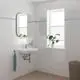 Weißes Waschbecken an der Wand mit integriertem Grohe-Waschtischarmatur. Neben dem Waschbecken ein Handtuchhalter und ein Fenster mit einer Pflanze auf der Fensterbank.