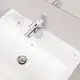 Grohe-Waschtischbatterie mit einem chromfarbenen, modernen Design, installiert auf einem weißen Waschbecken. Im Hintergrund liegt eine Tube und ein Behälter.