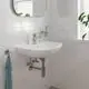 Waschtisch mit Grohe Armatur, ovaler Waschbeckenoberfläche, Wandmontage, Chromelemente, Handtuchhalter und Spiegelfläche vor gefliester Wand.