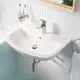 Waschtisch mit Grohe Armatur, mit Wasserfluss und Abfluss. Im Hintergrund sind ein Spiegel und ein Zahnputzbecher mit Zahnbürsten sichtbar. Fliesen im unteren Bereich.