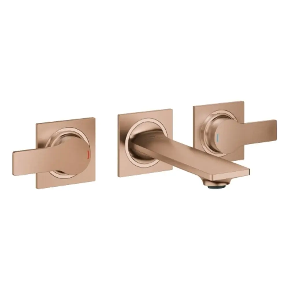 Grohe Wandbatterie mit zwei Bedienknöpfen für heiße und kalte Wasserabgabe sowie einem mittigen Wasserhahn. Oberfläche in warmem Sunset-Finish.