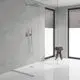 Dusche mit einer klaren Glasabtrennung und einem Wandmischer von Grohe. Der Raum hat helle Wände und große Fenster mit Jalousien sowie einen Hocker mit Handtüchern.