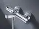 Grohe-Wannenbatterie mit zwei Grifffunktionen und Wandmontage, ausgestattet mit einem verchromten Finish, montiert an einer grauen Wand.