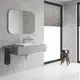 GROHE Eurocube Waschbeckenarmatur in chrom, mittelhohe Ausführung, montiert an einem modernen Waschbecken mit grauem Unterschrank und großen Fenstern im Hintergrund.