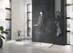 Weißes Duschsystem mit Handbrause und schwenkbarem Kopfteil, montiert an dunkler Wand. Grohe-Armatur und Glas-Duschabtrennung im modernen Badezimmer.