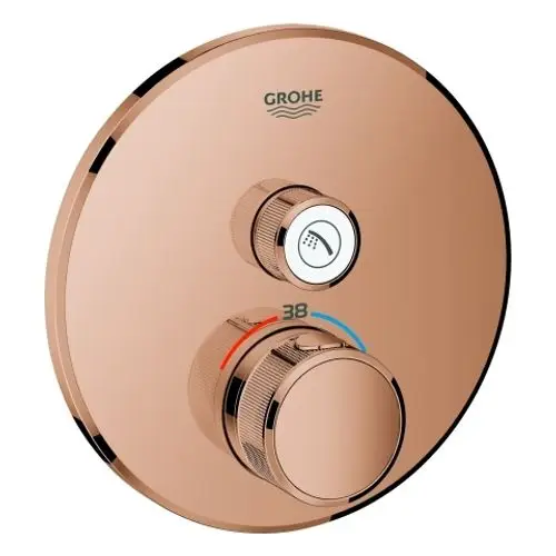 Kreisrundes Thermostat mit zwei Reglern von Grohe, einer zur Temperaturregelung und einer zur Strahlartenwahl, auf einer rosefarbenen Oberfläche.