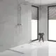 Dusche mit Grohe Duschsystem, bestehend aus Handbrause und Kopfbrause, an Wand montiert. Sicht auf helle Fliesen, Glasabtrennung und gefaltete Handtücher auf einem Holzstuhl.