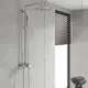 Duschanlage mit einer großen Regenbrause und Handbrause von Grohe, wandmontiert, Chrom-Oberfläche, vor hellen Wänden und Fenster mit Jalousien. Handtücher auf einem Holzstuhl.