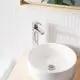 GROHE Waschtischbatterie mit einem glatten chromfarbigen Körper über einem runden Waschbecken, montiert auf einer Holzoberfläche, vor einer Mosaikfliese.