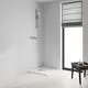Grohe-Handbrause mit verchromtem Griff, montiert an einer Wand, neben einer Duschwanne in einem modernen, minimalistisch gestalteten Raum.