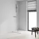 Brausegarnitur von Grohe mit Handbrause und Halterung an Wand montiert. Dusche in minimalistischem Innenraum mit Holzfußboden und Fenster.