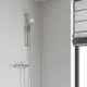 Brausegarnitur von Grohe mit Handbrause, montiert an einer Wand. Sichtbare Wandhalterungen und ein Schlauch sind vorhanden, daneben ein Fenster mit einem grauen Rollos.