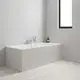 Grohe-Duschsystem an einer grauen Wand, bestehend aus einer Badewanne mit verchromten Armaturen und einer Handbrause mit Schlauch. Naturstein-Dekor auf dem Badewannenrand.