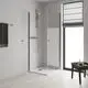 Duschbereich mit transparenten Türpaneelen. Grohe Duschsystem mit Handbrause an Wandhalterung, Wandmontage und Duschwanne. Helle, moderne Raumgestaltung.