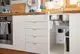 Unterbauschrank in einer modernen Küche mit Spüle und Abfallbehälter. Ein Vaillant-Gerät ist im Schrank sichtbar, neben zwei Spülbecken und der Rohreinstallation.