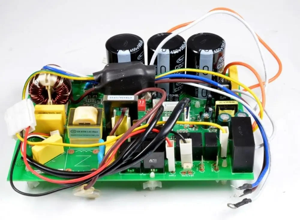 Steuerplatine von Remko mit mehreren Kondensatoren, Relais und verschiedenen elektrischen Verbindungen, montiert auf einer grünen Leiterplatte.