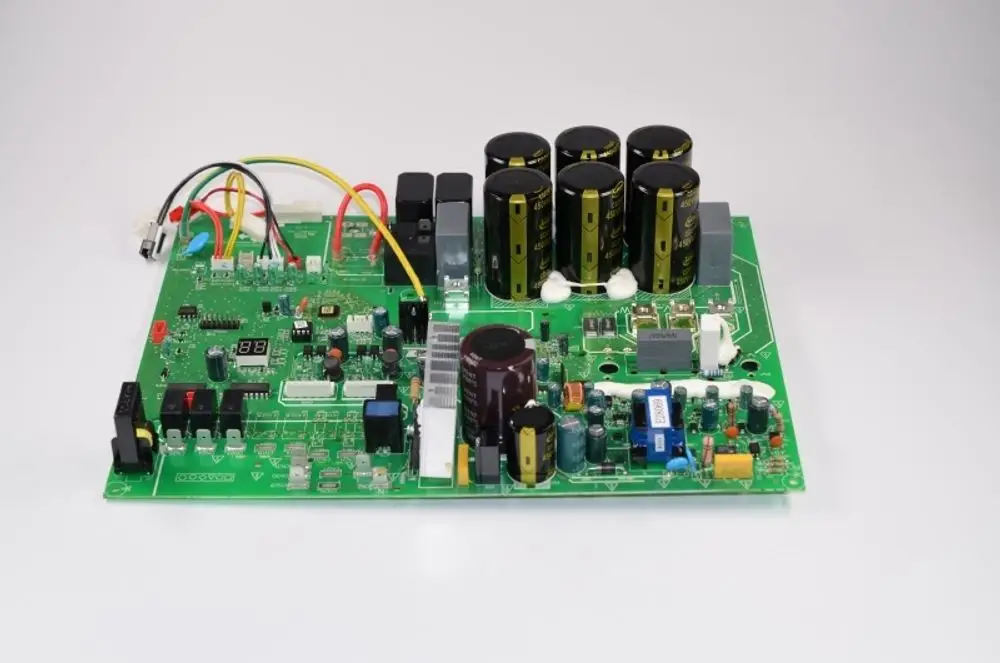 Grüne Leiterplatte mit verschiedenen elektronischen Bauteilen, darunter Kondensatoren und Relais. Das Produkt stammt von der Marke Remko.