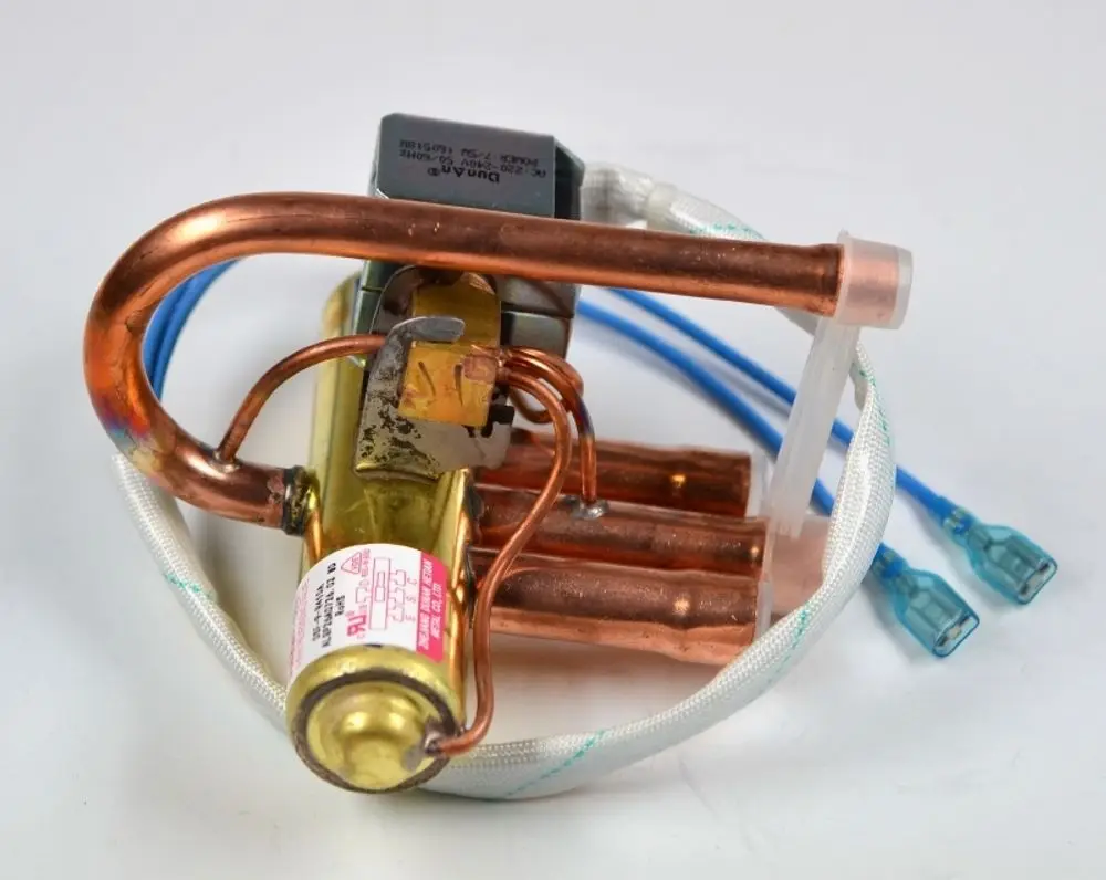 Vier-Wege-Ventil von Remko, mit Kupferrohren und elektrischer Steuerung, zur Regelung des Kältemittelflusses in Kühlsystemen.