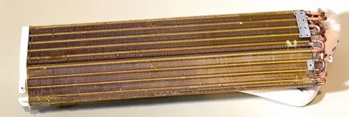 Verdampfer von Remko mit mehreren Kupferrohren und Lamellen. Das Bauteil ist länglich und hat einen weißen Kunststoffabschluss an einem Ende.