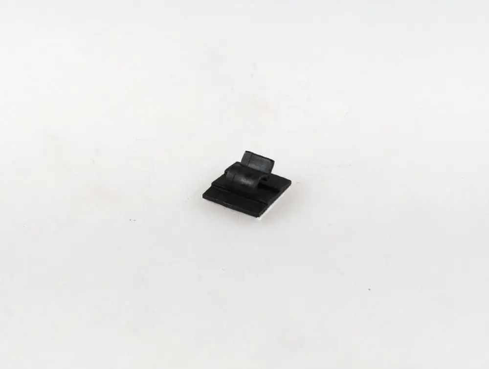 Schwarzer Kabelclip auf weißem Hintergrund, selbstklebend. Produkt von Remko zur Befestigung von Kabeln.