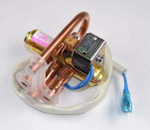 Umkehrventil von Remko mit Kupferrohren und elektrischen Anschlüssen. Sichtbare Komponenten sind eine kleine Steuerplatine und ein verchromter Körper.
