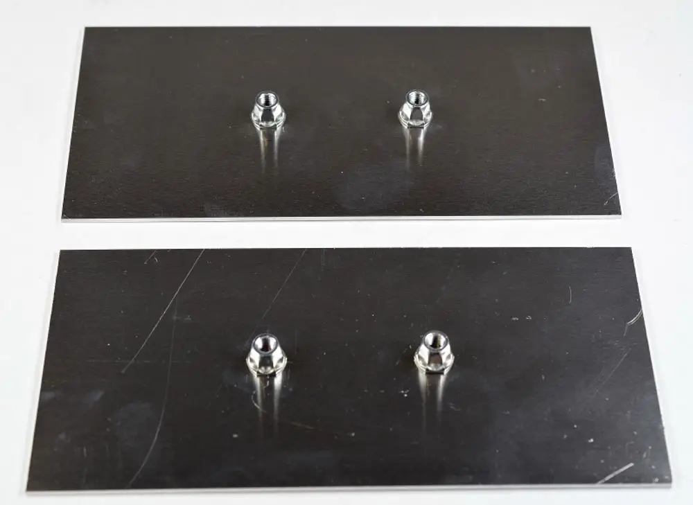 Zwei metallene Verstärkungsbleche von Remko mit je einem zentralen Gewindepunkt, auf einer neutralen Unterlage angeordnet.