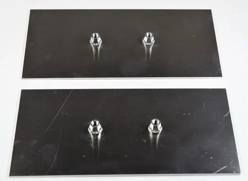 Zwei metallene Verstärkungsbleche von Remko mit je einem zentralen Gewindepunkt, auf einer neutralen Unterlage angeordnet.