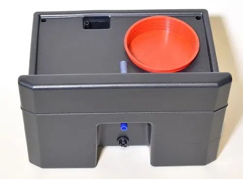 Schwarzer Kondensatbehälter mit rotem Deckel und blauer Anschlussleitung. Entwässerungsanschluss vorhanden. Produkt von Remko zur Behandlung von Kondensat.