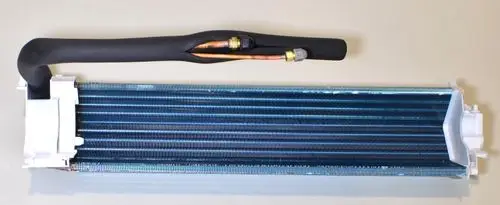 Verdampfer von Remko mit einem langen, lamellenförmigen Wärmetauscher und zwei angeschlossenen Kupferleitungen. Transparentes Gehäuse an beiden Enden sichtbar.