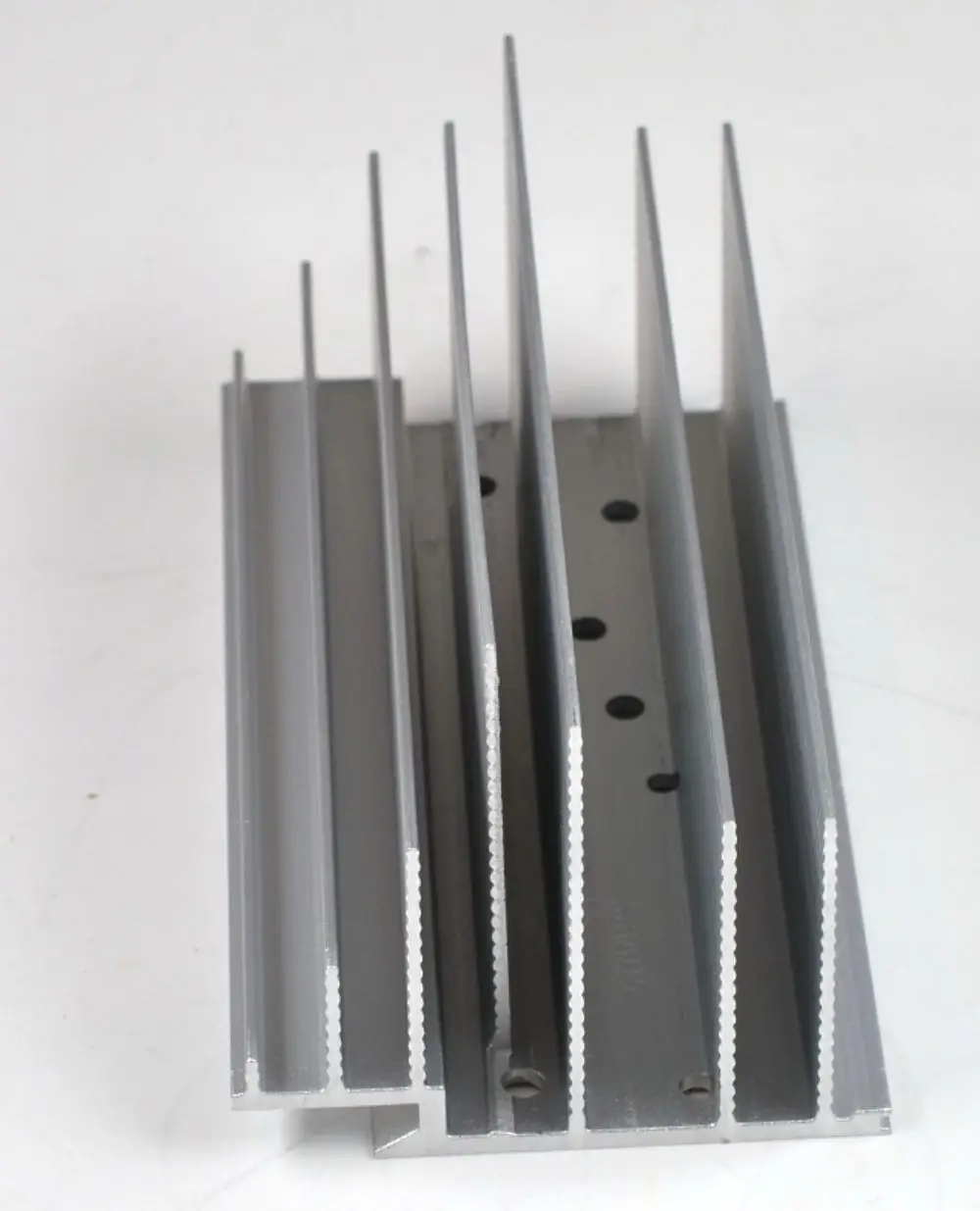 Kühlkörper aus Aluminium mit vertikalen Rillen. Die Anwendung könnte in der Kühlung oder Wärmeableitung liegen. Hergestellt von Remko.