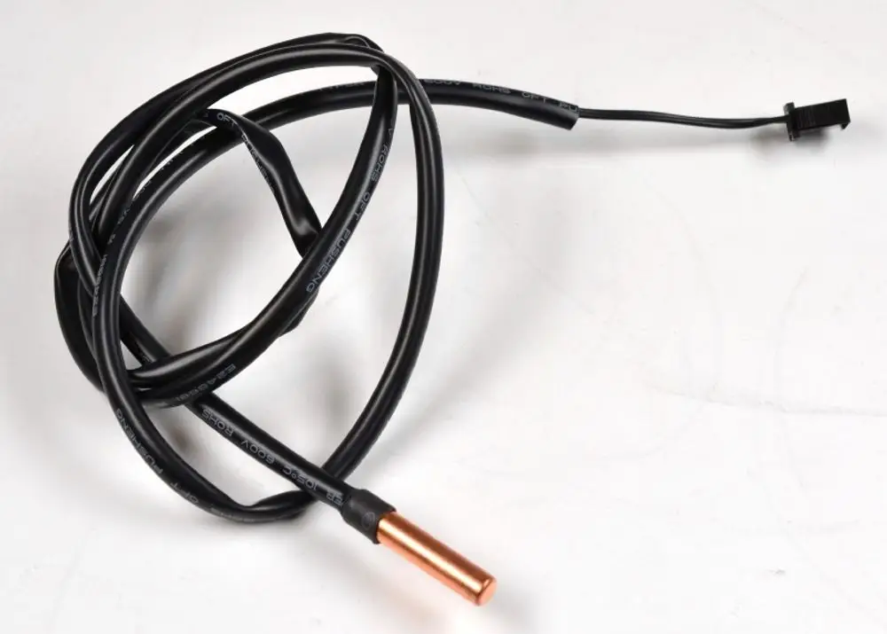 Rohranlegesensor mit schwarzen Kabeln und einem kupferfarbenen Ende, hergestellt von Remko. Das Kabel ist spiralförmig gewickelt und endet in einem steckerähnlichen Anschluss.