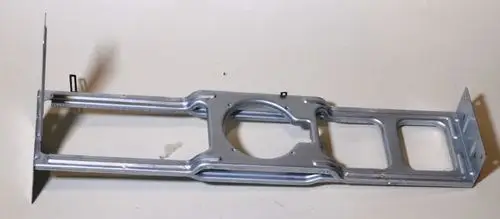 Halterung aus Metall für einen Ventilatormotor, gefertigt von Remko. Die Struktur ist länglich und weist Aussparungen zur Befestigung auf.