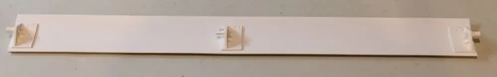 Weißes, rechteckiges Kunststoffteil mit drei Befestigungsnoppen und einem seitlichen Anschluss, möglicherweise Teil eines Heiz- oder Lüftungssystems von Remko.