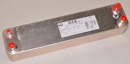 Wärmetauscher von Remko mit zwei Anschlüssen, montiert auf einer flachen, metallischen Oberfläche. Auf der Oberseite befindet sich ein Etikett mit technischen Informationen.
