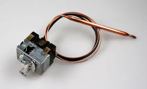 Thermostat mit einer Kupfer-Sensorleitung und mehreren Anschlussklemmen, gefertigt von Remko. Das Gerät ist für Heizsysteme konzipiert.