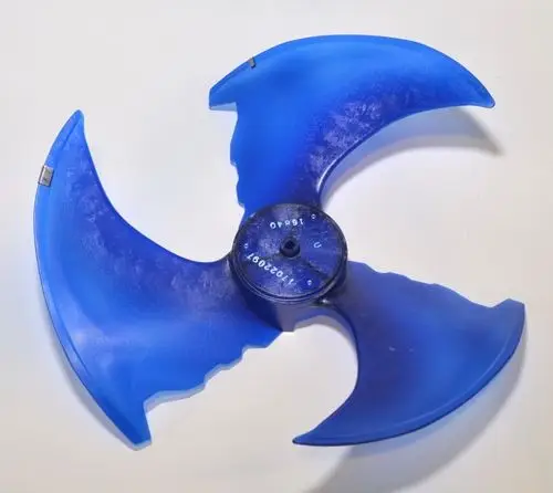Blauer Ventilatorflügel mit drei Flügeln, montiert auf einer zentralen Halterung. Teil eines Heiz- oder Klimageräts von Remko.