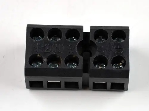 Schwarze Klemmleiste mit mehreren Anschlüssen für elektrische Verdrahtung, deutlich sichtbaren Schrauben und Markierungen, hergestellt von Remko.