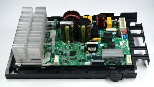 Steuerplatine von Remko mit Kühlkörper, elektrischen Komponenten, Spulen und verschiedenen Anschlüssen auf einer grünen Leiterplatte in einem schwarzen Gehäuse.