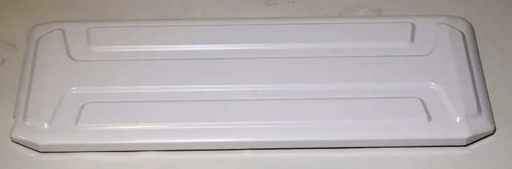 Weißes, flaches Blechstück mit einer glatten Oberfläche und leicht erhobenen Kanten. Es könnte Teil eines Remko-Geräts sein.