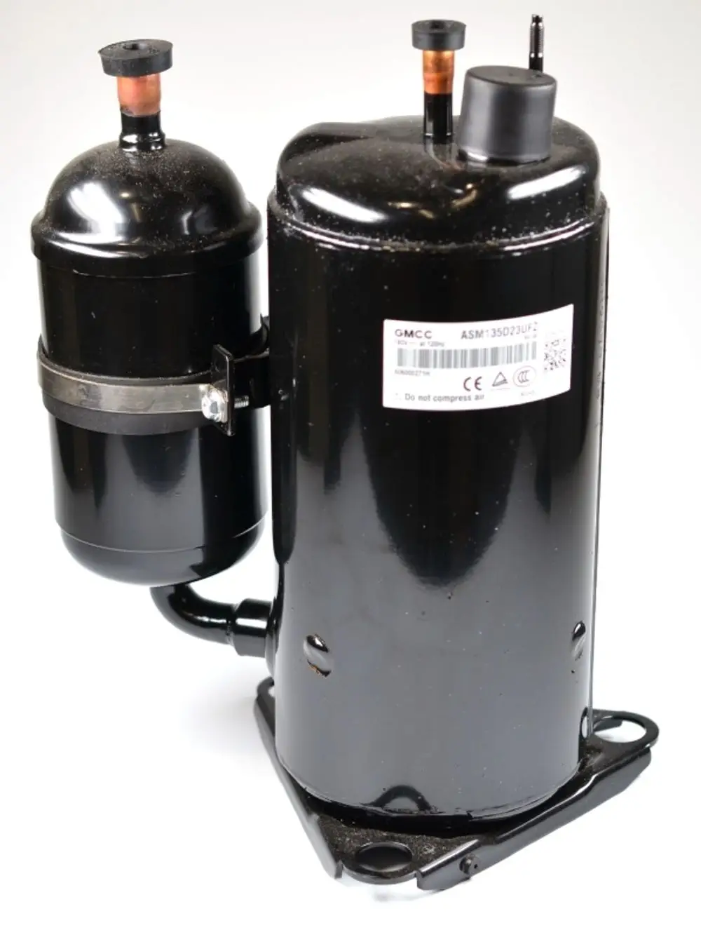 Schwarzer Kompressor mit zwei zylindrischen Teilen und Anschlussrohren, montiert auf einer Basis. Sichtbares Label mit der Marke Remko.