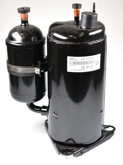 Schwarzer Kompressor mit zwei zylindrischen Teilen und Anschlussrohren, montiert auf einer Basis. Sichtbares Label mit der Marke Remko.