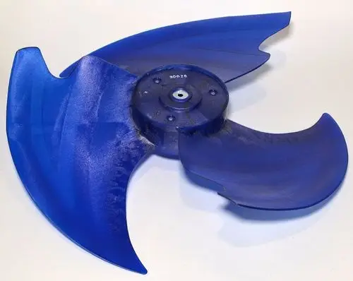 Blauer Ventilatorflügel, mit geschwungenen Kanten, für Verwendung in einem Remko-Gerät. Der Flügel hat eine zentrale Befestigungsaufnahme und ist aus Kunststoff gefertigt.