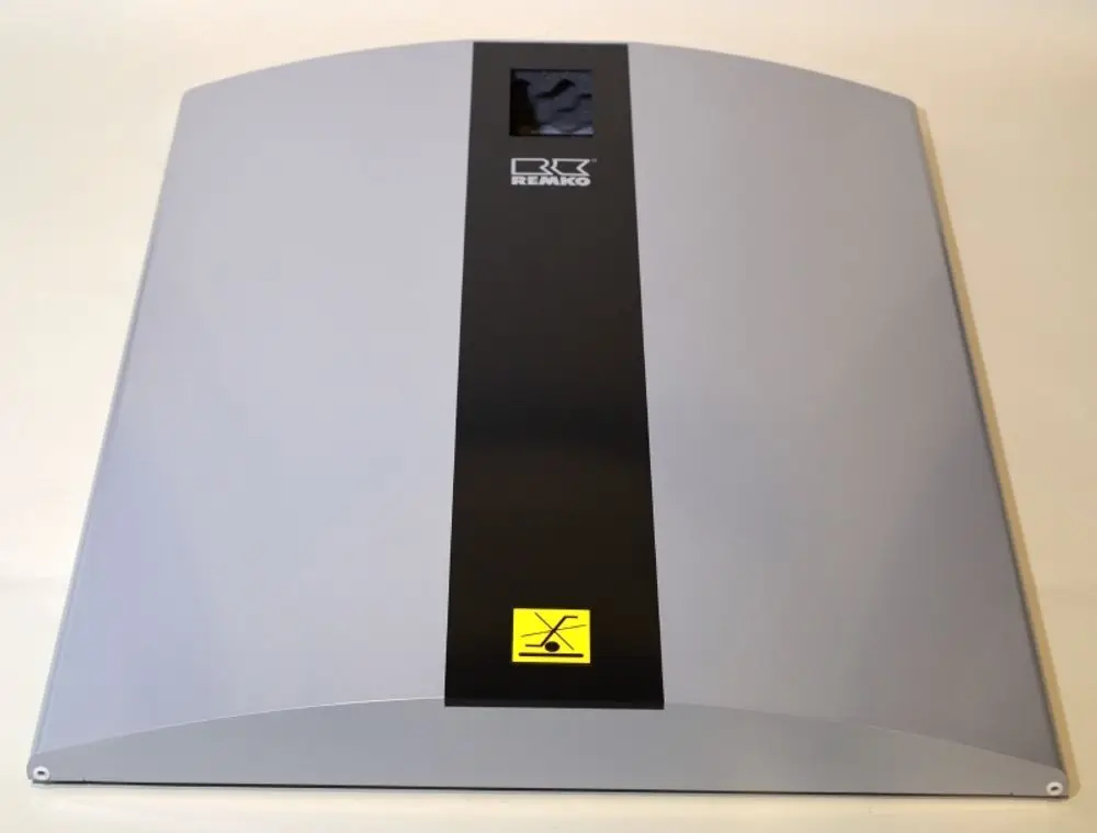 Remko Produkt mit einer glatten, grauen Oberfläche und einer zentralen schwarzen Leiste. Ein Warnsymbol ist sichtbar. Das Design ist flach und rechteckig geformt.